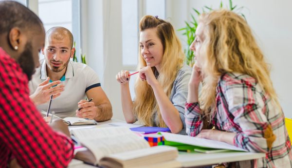 Adulto aprendiendo inglés en clase presencial con método conversacional